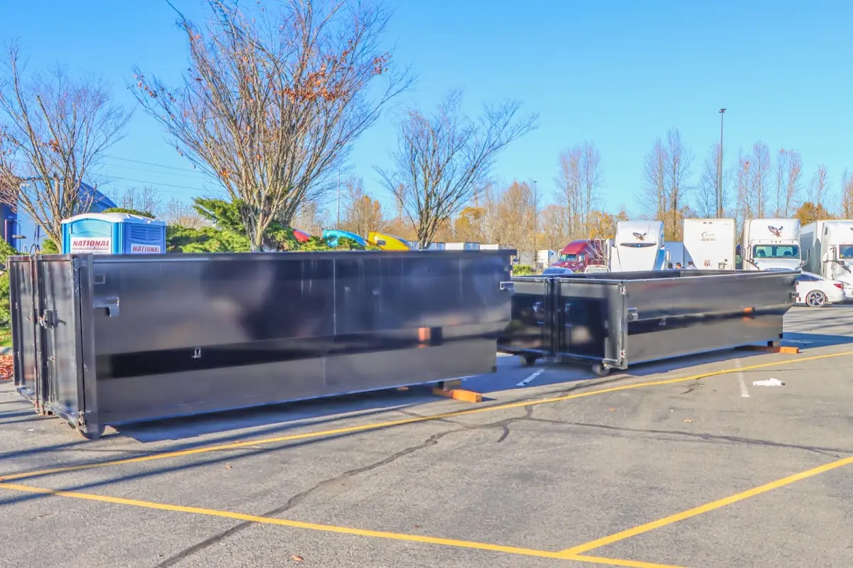 Professional dumpster rental service with roll-off container on residential driveway in Locust Grove